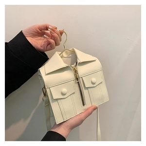 Close-up of a creative mini jacket-shaped crossbody bag hanging on a gold metal hanger