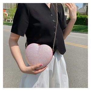 Detail of heart-shaped crossbody bag featuring purple gradient sequins and gold chain