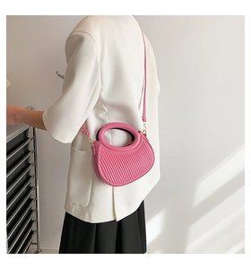 Détails du sac demi-lune plissé rose avec poignée en métal doré et texture en cuir PU
