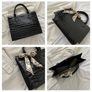 Black crocodile embossed tote bag detail with silk scarf and spacious inner capacity