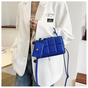 Detail of royal blue quilted handbag with bubble texture and mini matching charm pouch