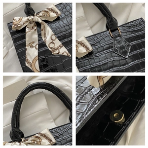 Detail shots of black embossed crocodile leather handbag with silk scarf and magnetic closure