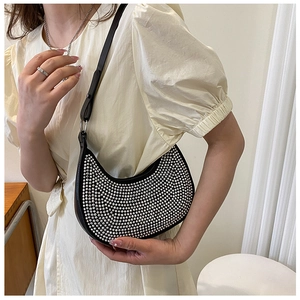 Detail of black crescent hobo bag with silver rhinestone studs and leather shoulder strap