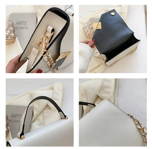 Detail of white leather handbag with black contrast edges and gold hardware lock