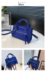 Close-up detail of blue structured satchel featuring motor-style tassels and silver hardware