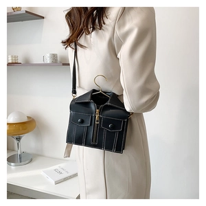 Detail of creative black biker jacket bag with gold hanger hook and leather strap