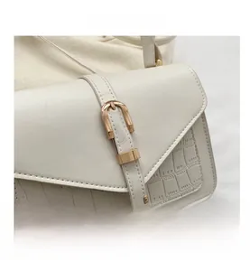 Detail view of white crocodile pattern texture and golden horseshoe metal buckle