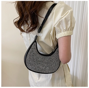 Detail view of black hobo bag with silver studs and adjustable strap on model