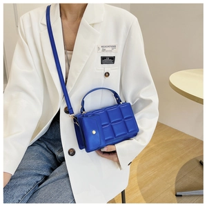 Detail of royal blue quilted crossbody bag with a matching detachable mini coin purse