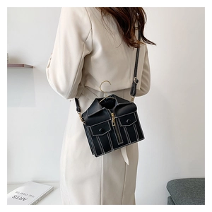 Detailed view of creative black jacket-shaped handbag with gold hanger handle