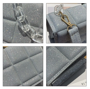 Detail of silver sequin quilted crossbody bag featuring transparent acrylic chain link strap