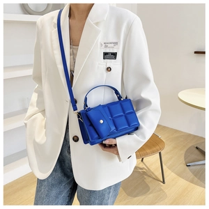 Detail of blue quilted crossbody bag with a matching mini coin purse pouch