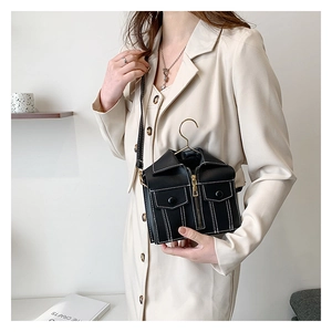 Detail of mini black biker jacket bag with gold zippers and white contrast stitching