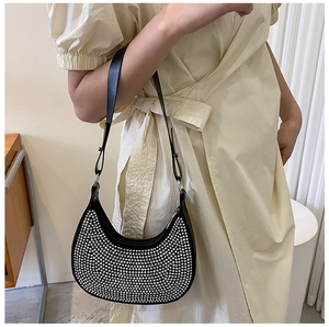 Detail view of stylish black hobo bag featuring silver metal studs and a slim strap