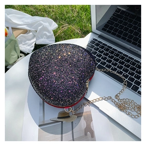 Detail shot of heart-shaped crossbody bag with sparkling colorful sequins and gold chain