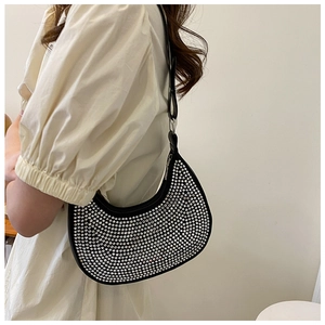 Detail of trendy black crescent underarm bag with silver rhinestones on a fashion model