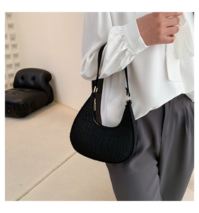 Dettaglio di una borsa sottobraccio in feltro nero alla moda con un design a mezzaluna unico