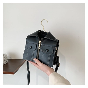 Detail of creative jacket shaped crossbody bag with metallic zippers and white stitching