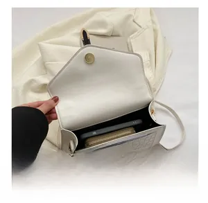 Internal capacity of white crocodile pattern shoulder bag showing phone and wallet