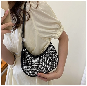 Close-up of a crescent underarm bag with silver rhinestones and black leather strap