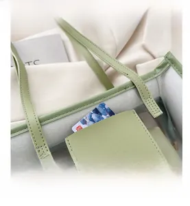 Detail of light green leather stitching and PVC texture on a waterproof tote bag