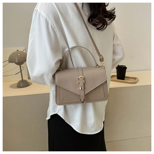 Detailed view of taupe crossbody bag featuring crocodile texture and gold horseshoe buckle