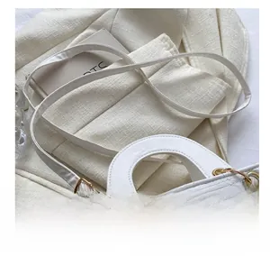 Detail of white quilted handbag showing gold metal buckle and adjustable leather shoulder strap