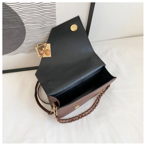 Detail view of the black and brown patchwork shoulder bag with gold chain strap