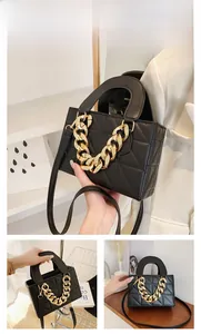 Detail of black quilted PU leather handbag with decorative chunky gold chain and shoulder strap