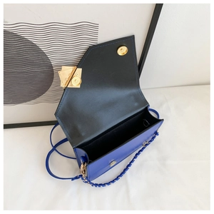 Blue geometric crossbody bag showing magnetic gold buckle and interior storage