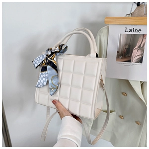 Détail du sac en cuir matelassé avec foulard en soie décoratif sur la poignée