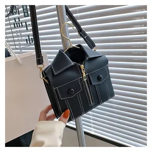 Detail view of jacket-shaped crossbody bag with contrast stitching and metal zippers