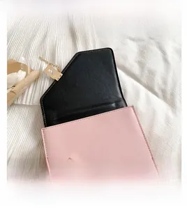 Detailed view of pink crossbody bag showing gold rectangular clasp and black flap interior