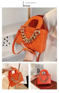 Detail of orange quilted handbag with chunky gold chain and dual strap options
