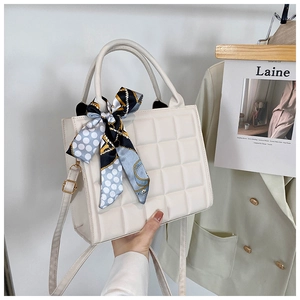 Détail du sac crème avec gaufrage carré et foulard en soie imprimé sur la poignée