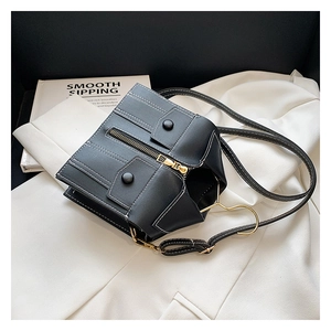 Detailed view of a unique black jacket-shaped crossbody bag with silver zippers and stitching
