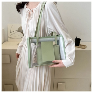 Detail of transparent PVC tote bag with green avocado inner pouch shown on a model