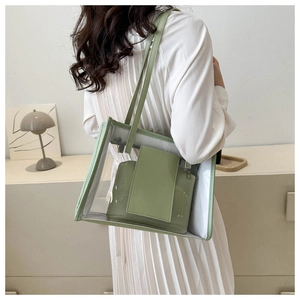 Detail of light green transparent jelly tote bag with inner pouch on a shoulder model