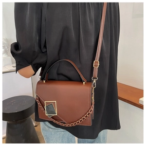 Detail of vintage brown PU leather crossbody bag featuring gold metal buckle and woven chain