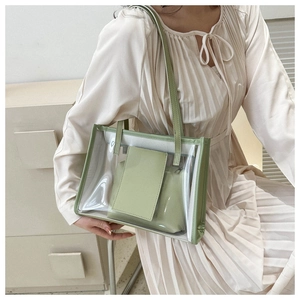 Detail of transparent PVC jelly tote bag with green PU inner pouch and long strap