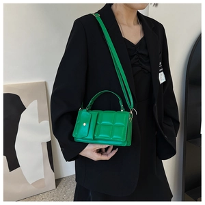 Close-up of green quilted tote bag featuring a matching mini pouch and fine PU leather texture
