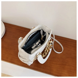 Detailed top view of white quilted handbag showing spacious interior and golden chain handle
