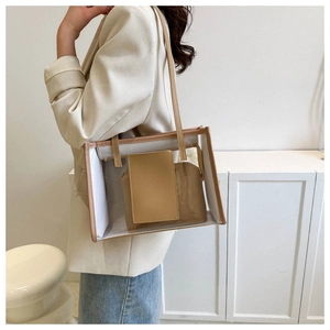 Detail view of transparent jelly tote bag with leather inner pouch and brown trim