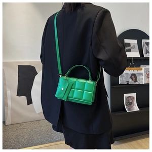 Detail view of bright green quilted handbag with matching coin purse and shoulder strap