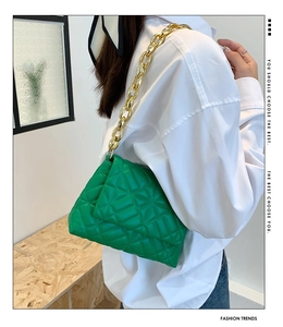 Detail of green quilted PU shoulder bag featuring chunky gold acrylic chain and cloud shape