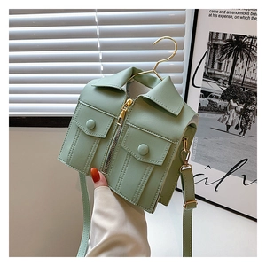 Detail of mint green jacket-shaped crossbody bag with zipper and gold hardware