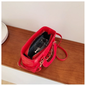 Interior view of red quilted bag showing large capacity and zipper compartment
