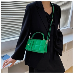 Detail view of quilted neon green mini bag with matching coin purse worn by model