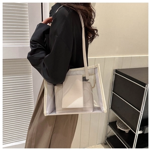 Detailed side view of transparent PVC tote bag with inner pouch and adjustable shoulder strap