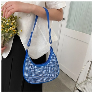 Detail of blue crescent hobo bag featuring silver rhinestones and adjustable leather strap